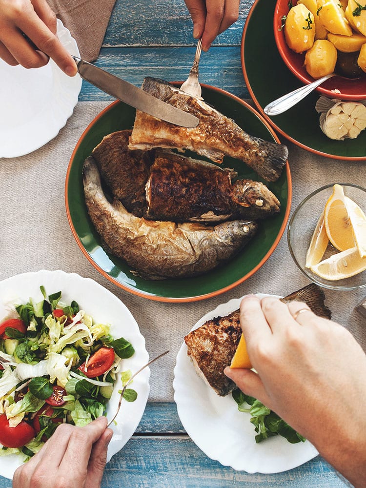 Family dinner with fried fish potato and salad